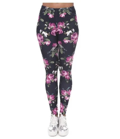 Women's floral print leggings with pink and white roses on black background, paired with silver sneakers