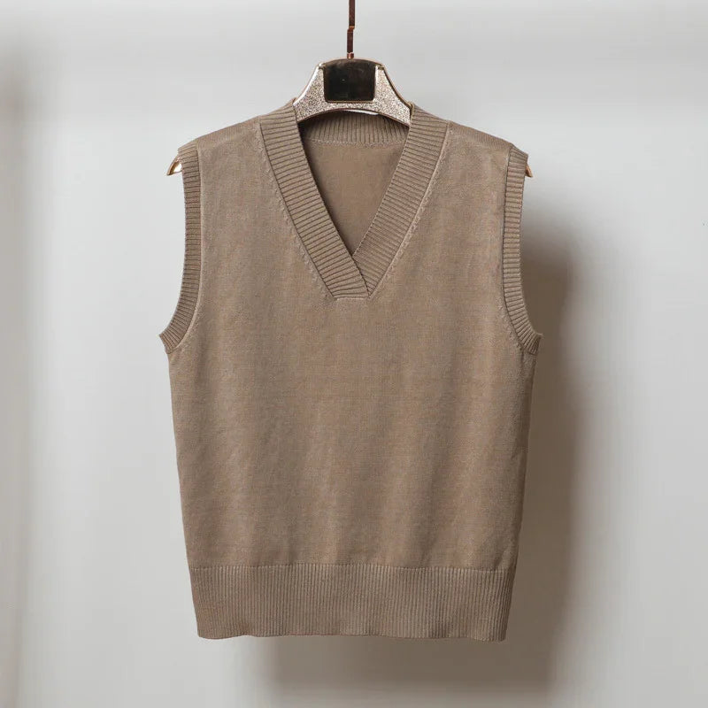 Beige knitted sleeveless V-neck sweater vest hanging on hanger against white background