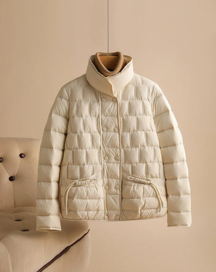 Beige quilted puffer jacket with high collar and front pockets on neutral background