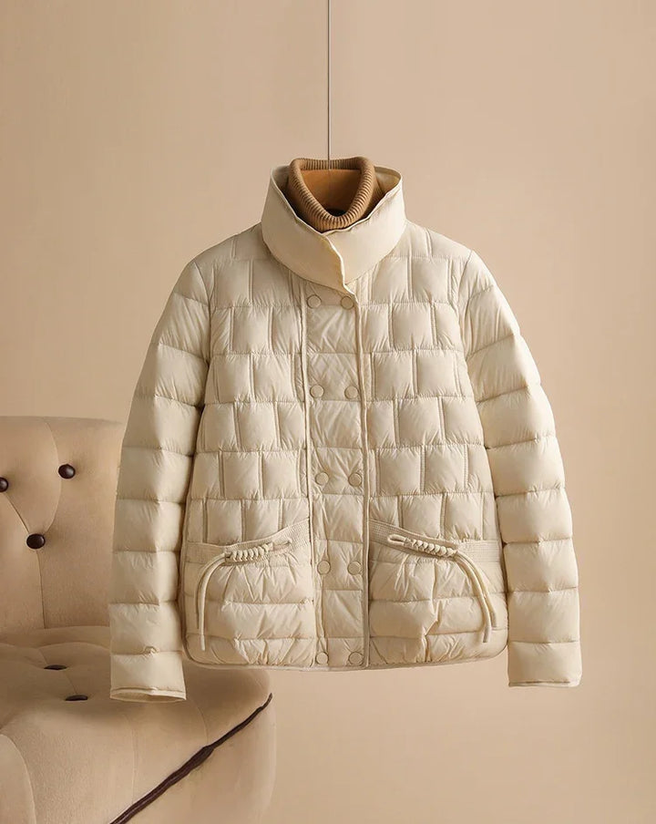 Beige quilted puffer jacket with high collar and front pockets on neutral background