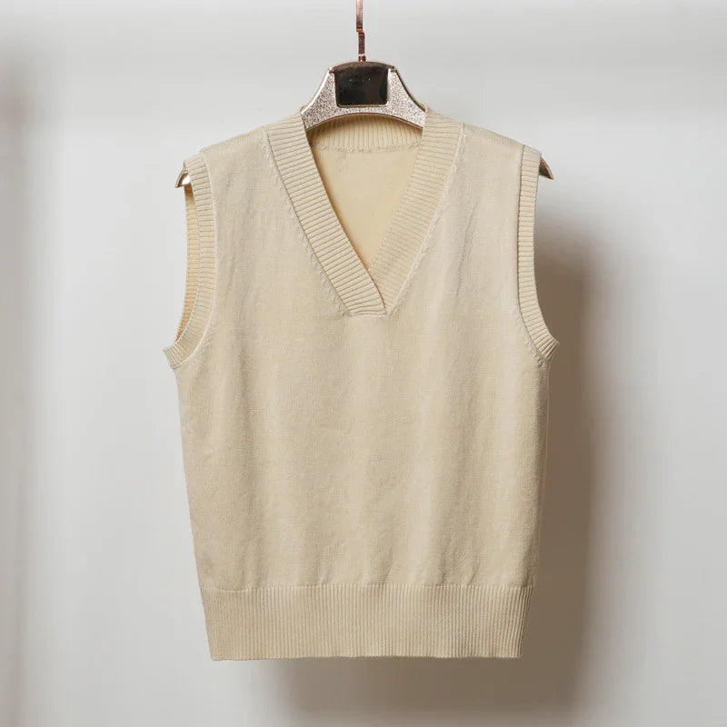 Beige sleeveless V-neck knit sweater vest hanging on decorative hanger against white background