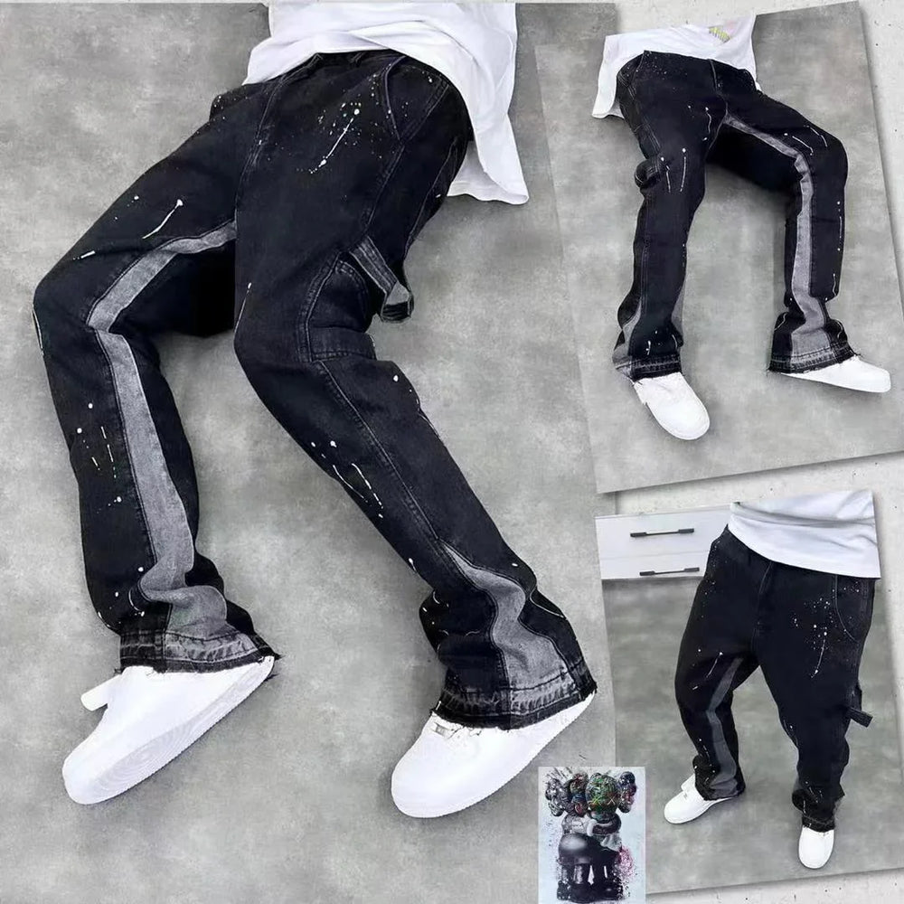 Black jeans with gray side stripes and white paint splatter details styled with white sneakers on gray background
