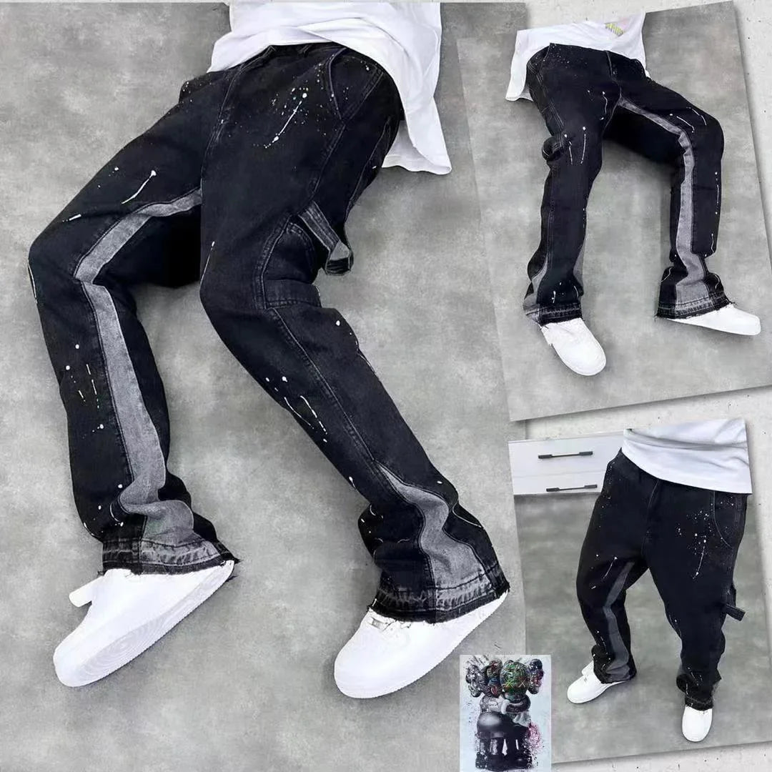 Black jeans with gray side stripes and white paint splatter details styled with white sneakers on gray background
