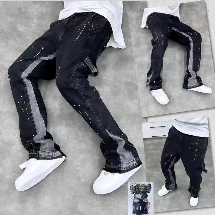 Black jeans with gray side stripes and white paint splatter details styled with white sneakers on gray background