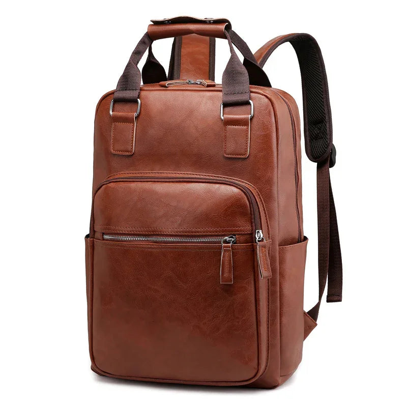 Brown leather backpack with front zippered pocket and padded shoulder straps on white background