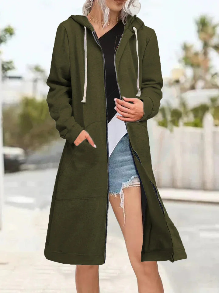Woman wearing long olive green zip-up hooded cardigan with pockets outdoors