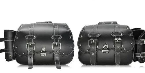Pair of black leather motorcycle saddlebags with silver buckles and white stitching