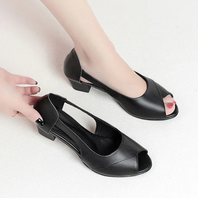 Black open-toe low heel women's shoes with side cutout detail on white background