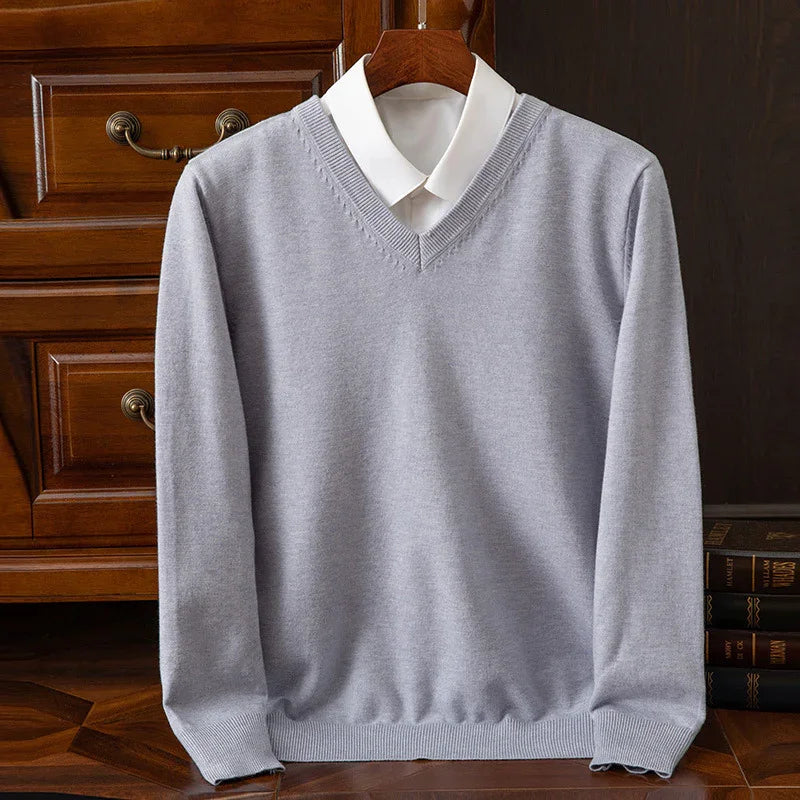 Light gray V-neck sweater layered over a white collared shirt, hanging on wooden hanger