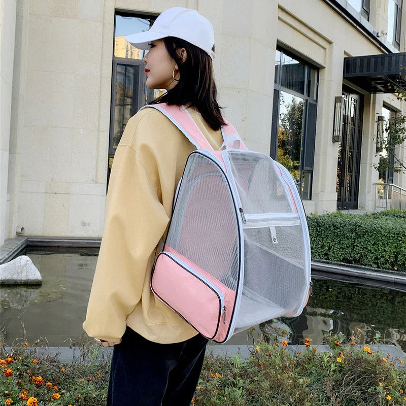 Woman wearing beige sweatshirt and white cap carrying large transparent pink mesh backpack outdoors