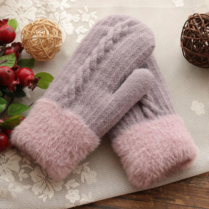 Cozy lavender knit gloves with pink faux fur cuffs on lace and wood background, decorative balls nearby
