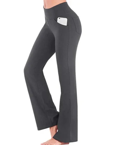 Woman wearing black flared yoga pants with side pocket holding a white smartphone