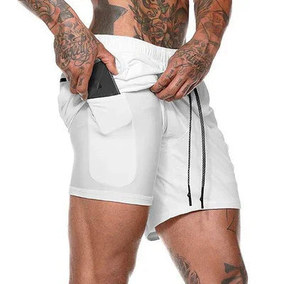 Tattooed man inserting smartphone into side pocket of white athletic shorts with black drawstrings