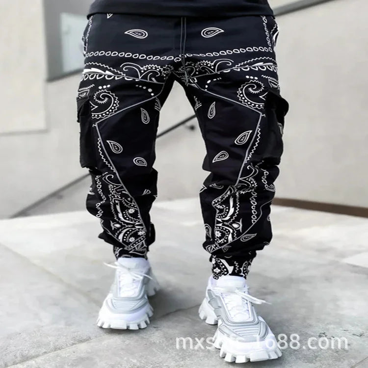 Black cargo pants with white paisley bandana print worn with white chunky sneakers