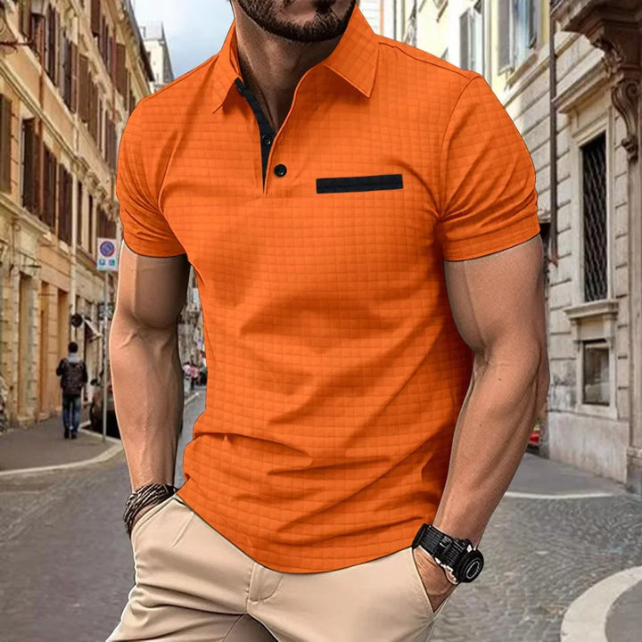 Man wearing orange short-sleeve polo shirt with black trim and beige pants on city street