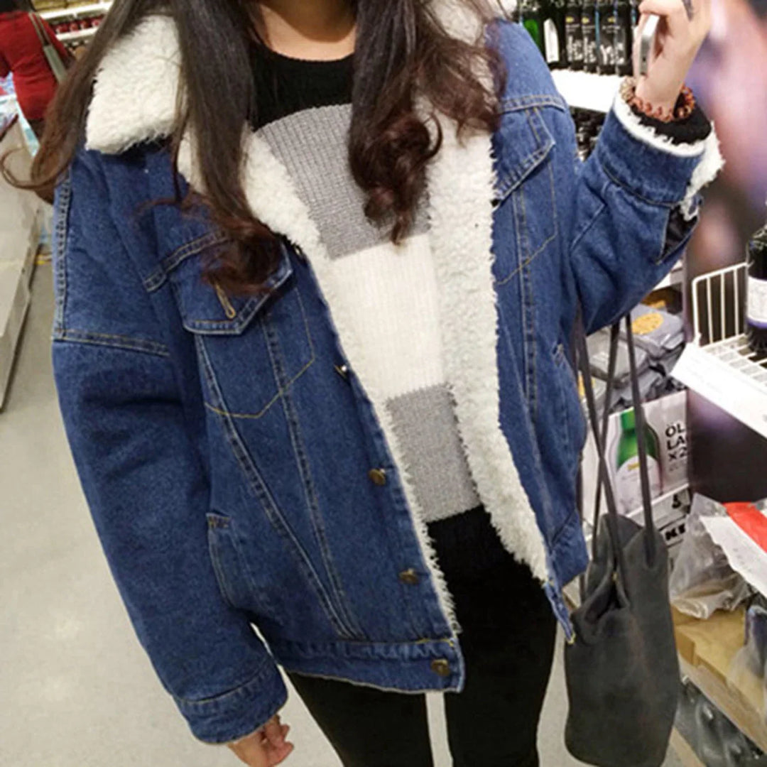 Woman wearing blue sherpa-lined denim jacket and striped sweater shopping in store