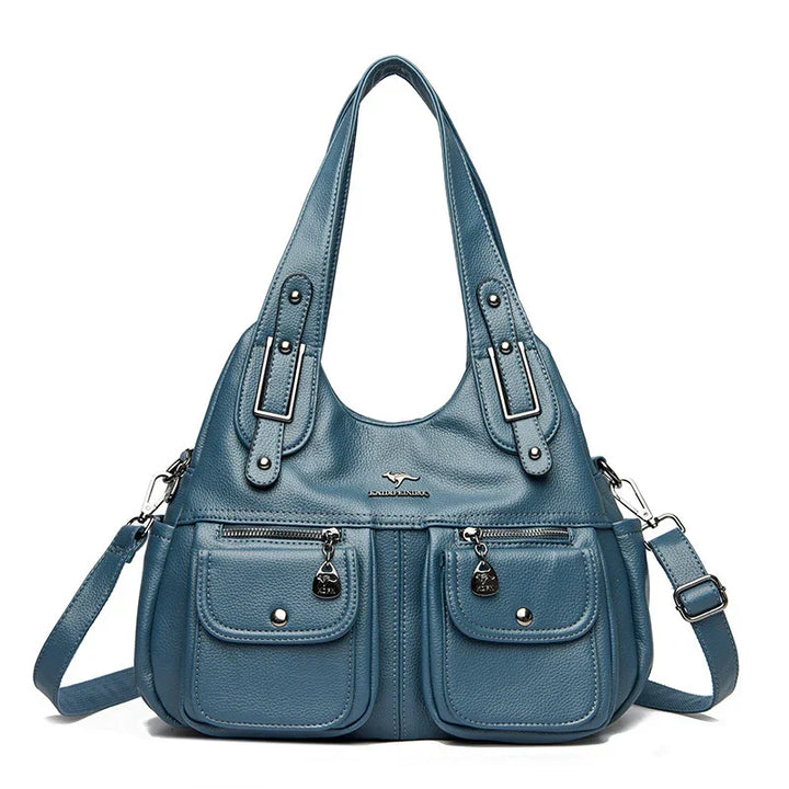 Blue leather handbag with dual front pockets, adjustable shoulder strap, and sturdy handles