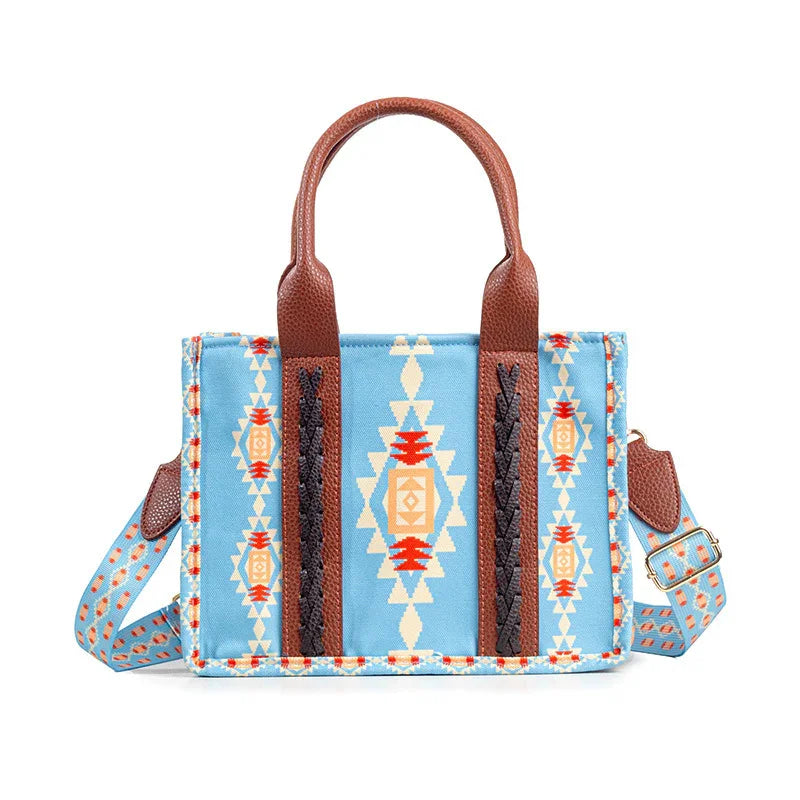 Blue tote bag with Southwestern geometric pattern, brown leather handles, and adjustable strap