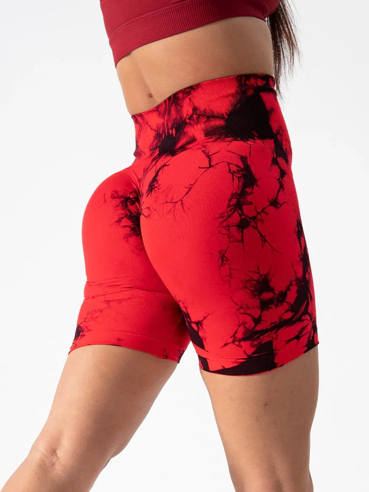 Close-up of woman wearing high-waisted red and black tie-dye biker shorts and red crop top