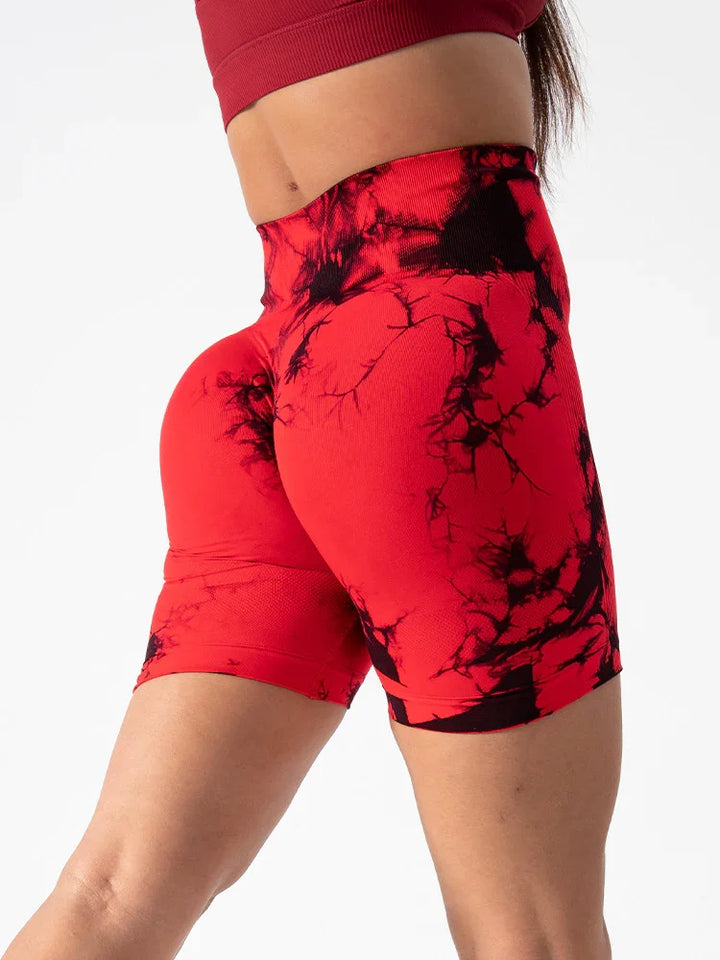 Close-up of woman wearing high-waisted red and black tie-dye biker shorts and red crop top