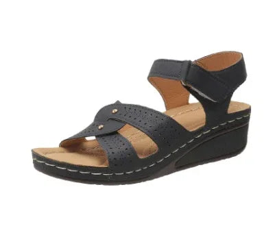 Black leather wedge sandal with perforated straps and ankle closure on white background