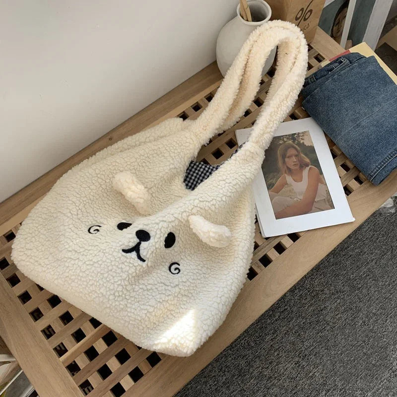 Cozy white teddy bear fleece tote bag with cute face and ears on wooden bench next to jeans and photo
