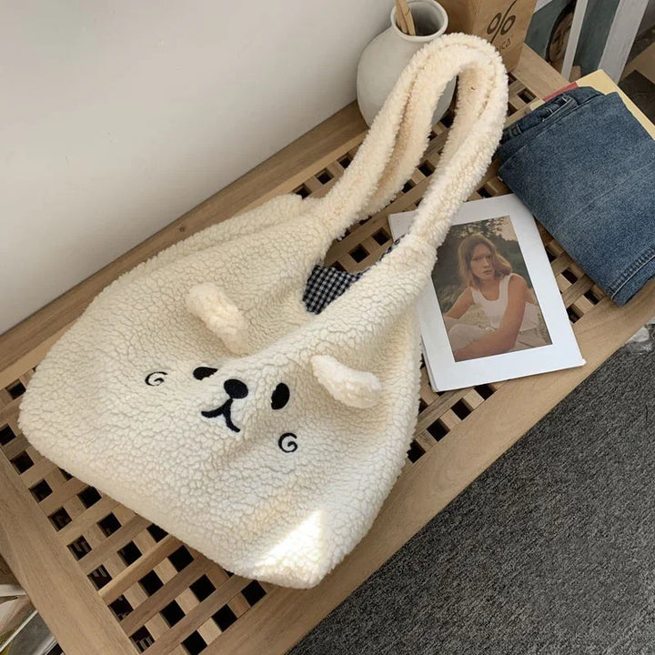 Cozy white teddy bear fleece tote bag with cute face and ears on wooden bench next to jeans and photo