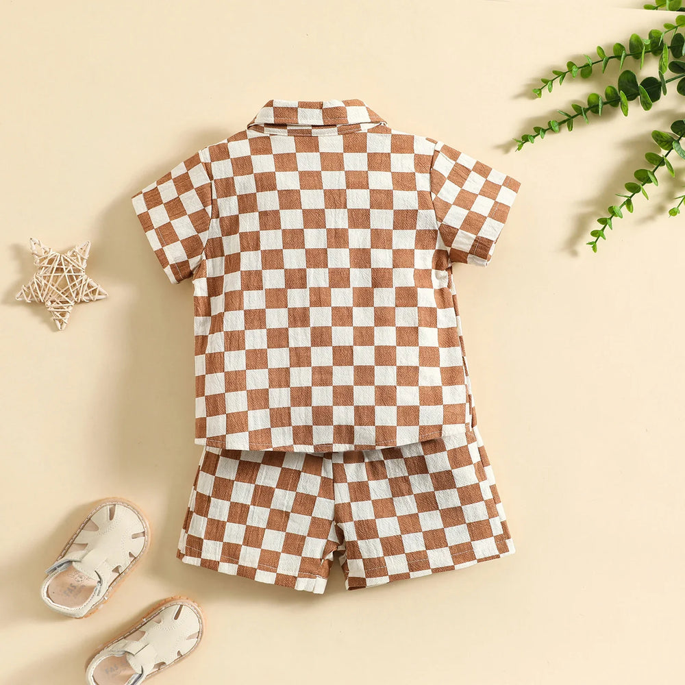 Children's brown and white checkered short-sleeve shirt and shorts set with beige shoes on beige background