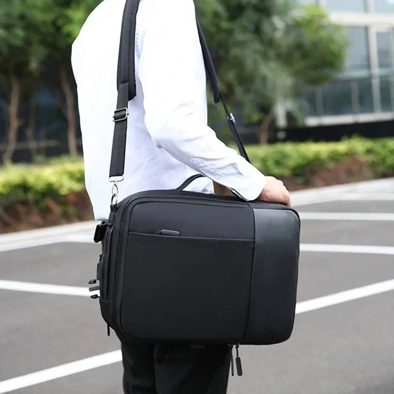 Person wearing white shirt carrying black laptop bag with shoulder strap outdoors