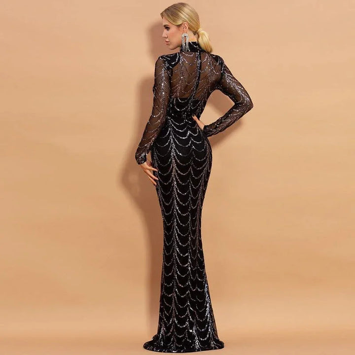 Blonde woman in black sequined long-sleeve evening gown with sheer back against beige background