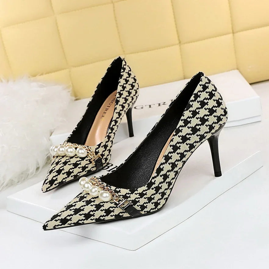 Pair of black and white houndstooth high heel pumps with pearl and chain embellishments