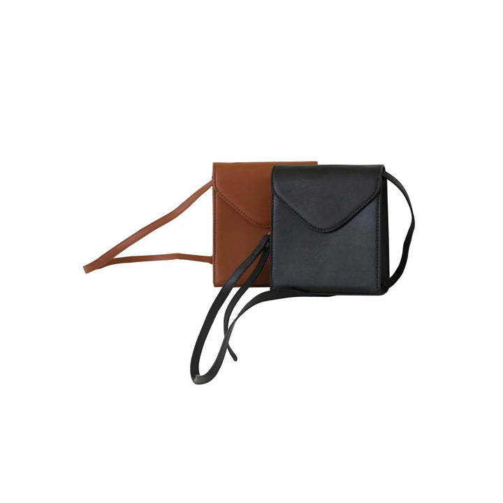 Minimalist black and brown leather crossbody bags with flap closures and long straps on white background
