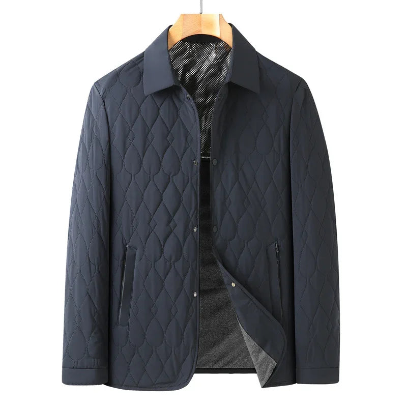 Men's navy blue quilted jacket with collar, snap buttons, and side pockets on hanger