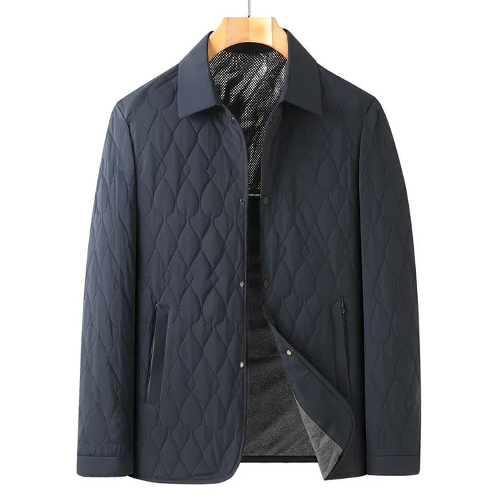 Men's navy blue quilted jacket with collar, snap buttons, and side pockets on hanger