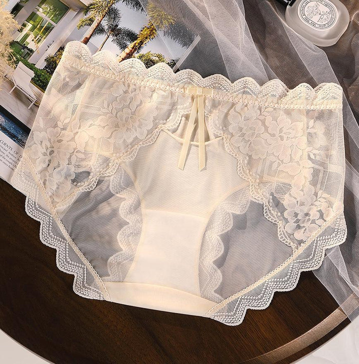 Elegant cream lace panties with floral embroidery and scalloped edges on wooden table