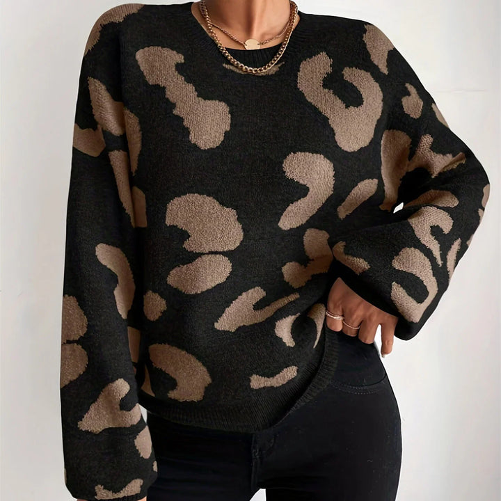 Woman wearing black and tan leopard print sweater with gold chain necklace and black pants