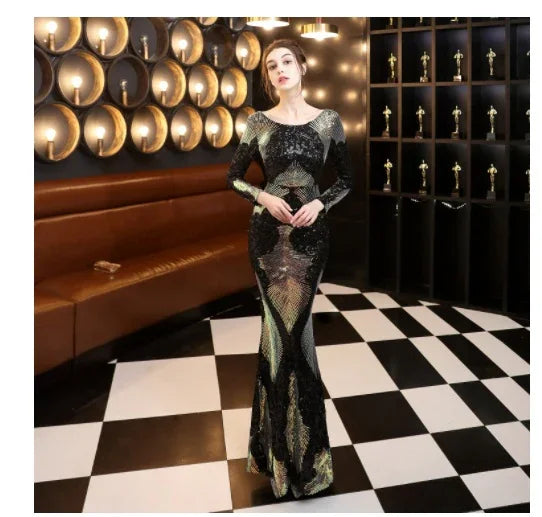 Woman in black and gold sequin evening gown standing on black and white checkered floor in elegant room