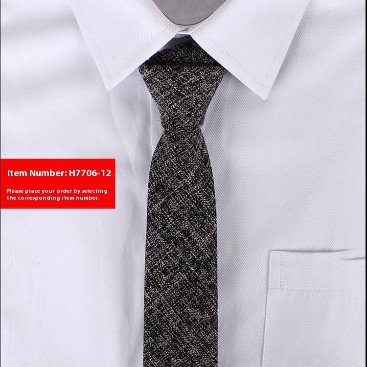 Close-up of black and white textured necktie paired with white dress shirt featuring a pointed collar