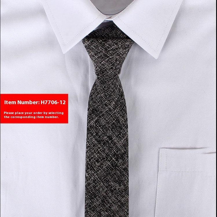 Close-up of black and white textured necktie paired with white dress shirt featuring a pointed collar