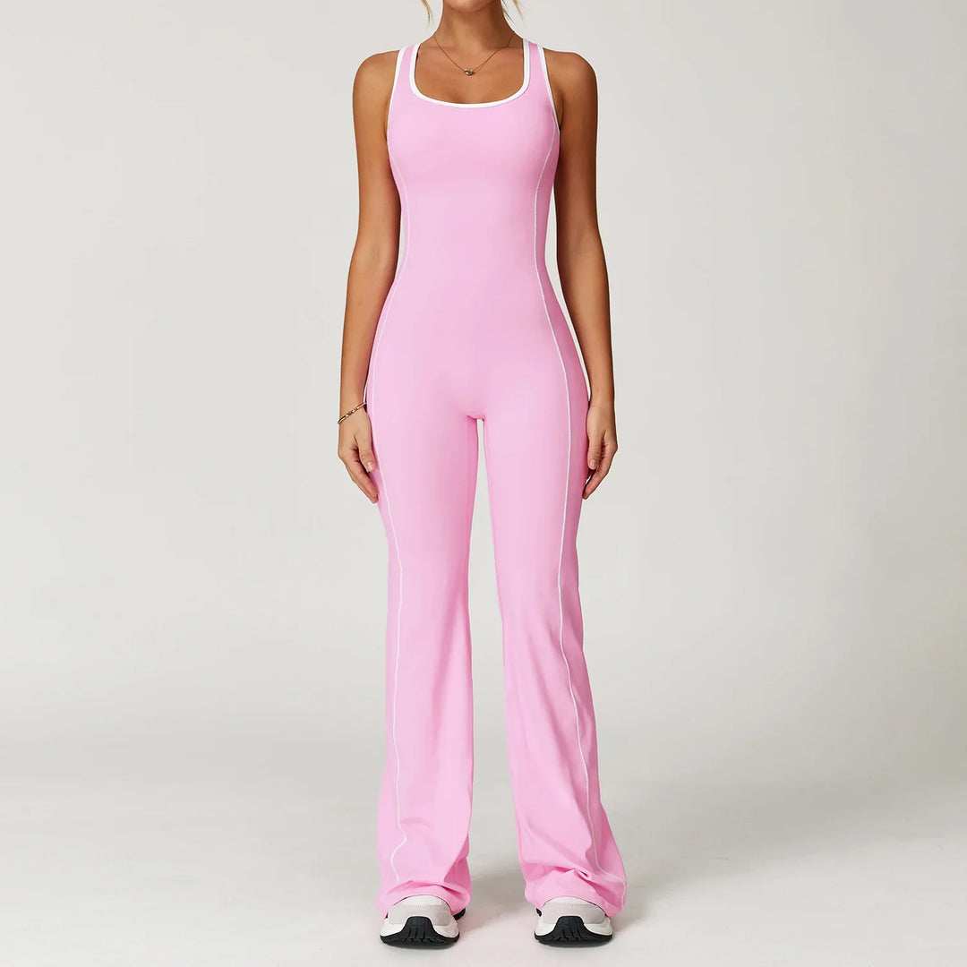 Woman wearing a pink fitted sleeveless jumpsuit with white piping and white sneakers