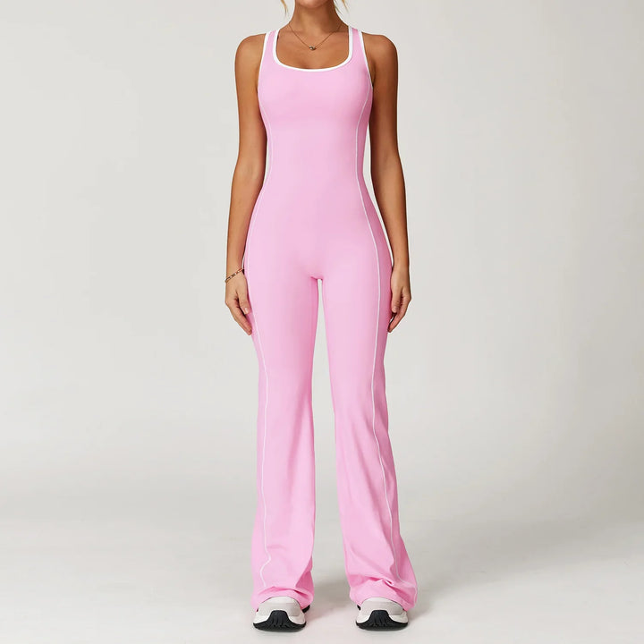 Woman wearing a pink fitted sleeveless jumpsuit with white piping and white sneakers