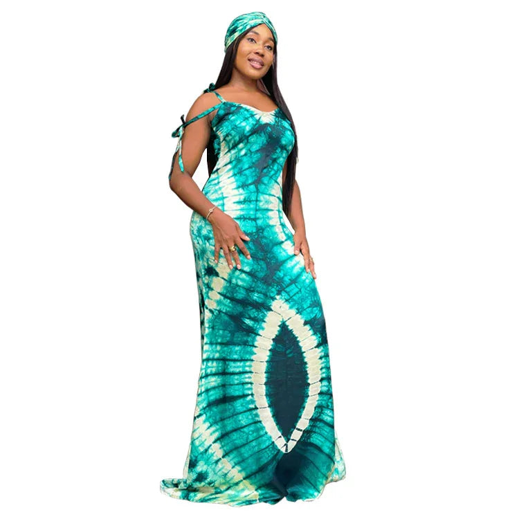 Woman wearing a turquoise and white tie-dye maxi dress with matching headwrap on white background