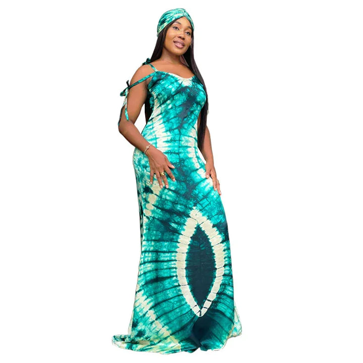 Woman wearing a turquoise and white tie-dye maxi dress with matching headwrap on white background