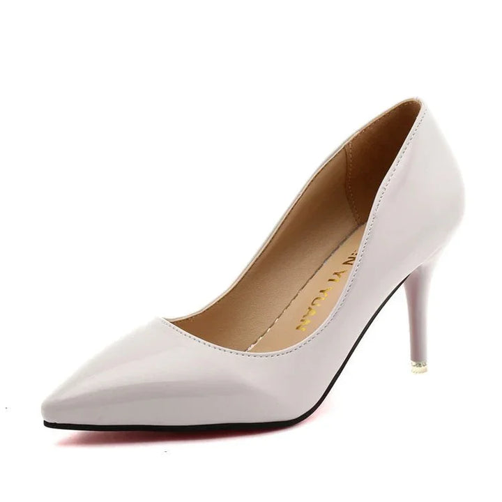 Elegant white patent leather pointed-toe high heel pump with stiletto heel on white background