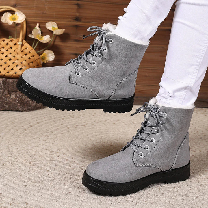 Gray suede winter boots with fur lining and black soles worn with white ripped jeans