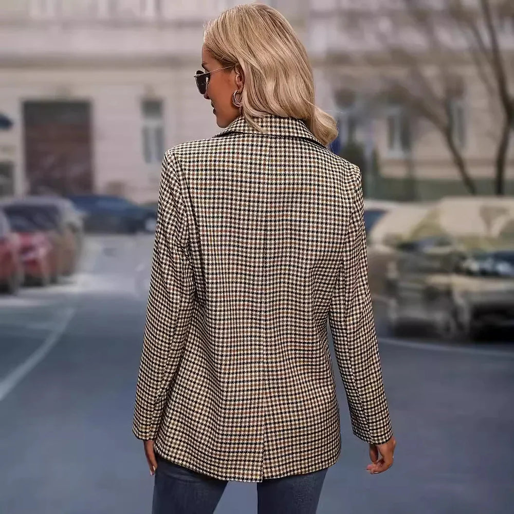 Woman wearing beige and brown checkered blazer with sunglasses standing on city street
