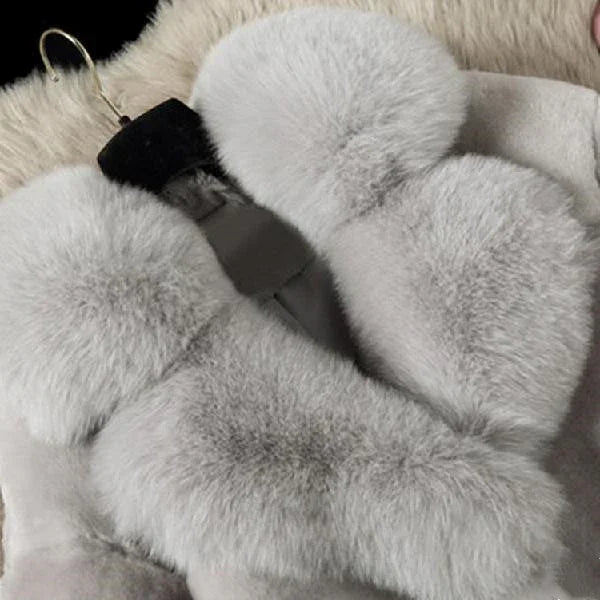 Light gray fluffy fur mittens on a black and beige fuzzy background