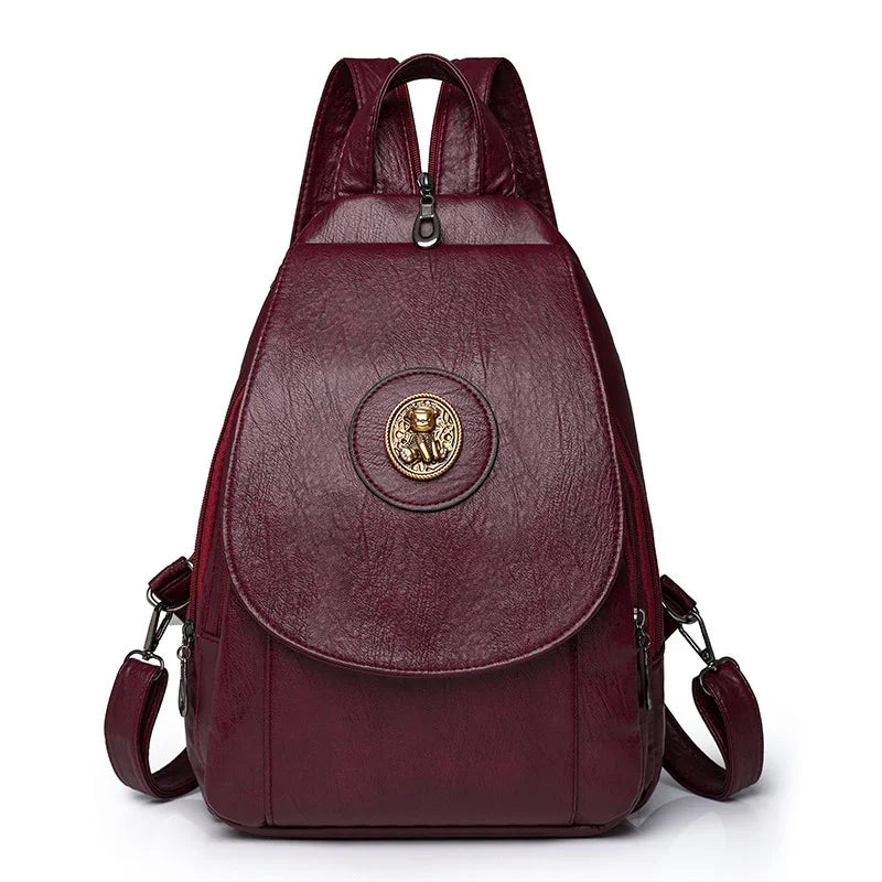 Burgundy leather backpack with gold emblem and adjustable shoulder straps