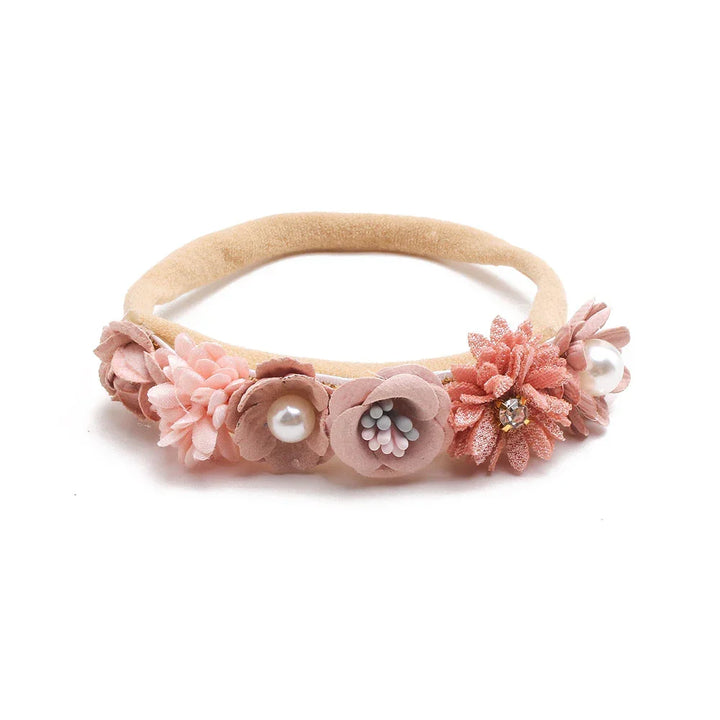 Beige floral headband with pink flowers, pearl accents, and rhinestone detail on white background