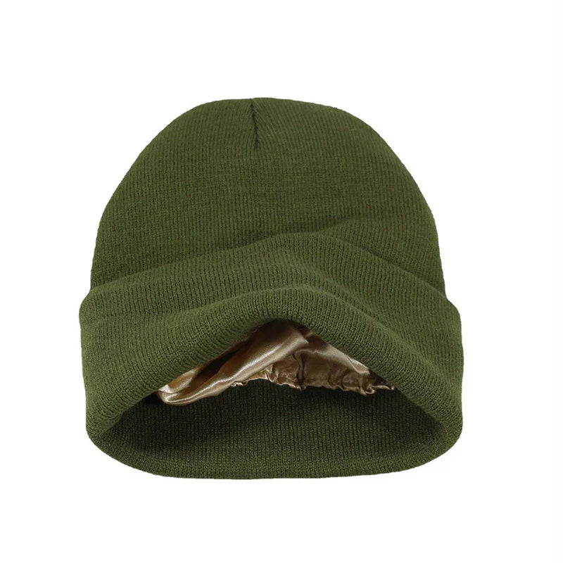 Olive green knit beanie hat with smooth satin lining inside, isolated on white background